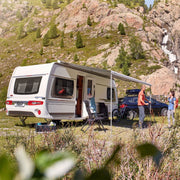 Camper van parked in a mountainous area with people around