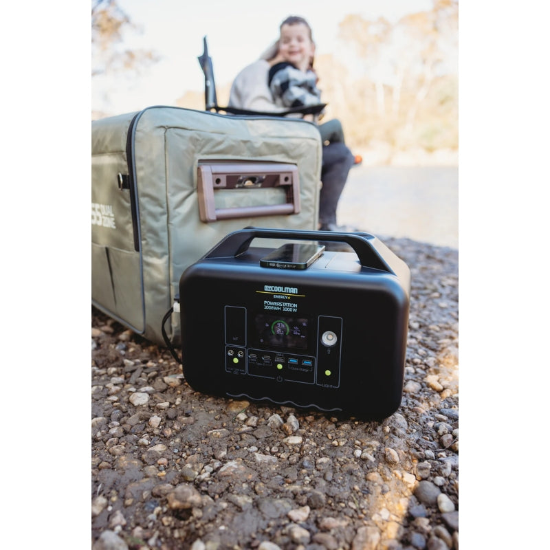 A sleek, black portable energy power station featuring an integrated carry handle and a digital interface display. The front panel includes multiple output options such as AC outlets, USB ports, and DC inputs for versatile off-grid charging