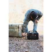 A rugged black portable energy power station with integrated carrying handles and a digital display. The front panel features a variety of output ports, including AC outlets, USB-A, and USB-C quick-charge ports for off-grid power.